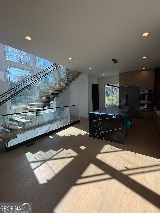 interior space with recessed lighting, visible vents, stairs, and wood finished floors