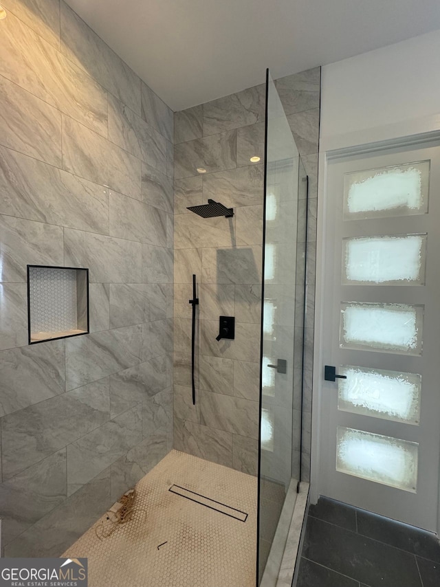 full bath featuring a tile shower and tile patterned flooring
