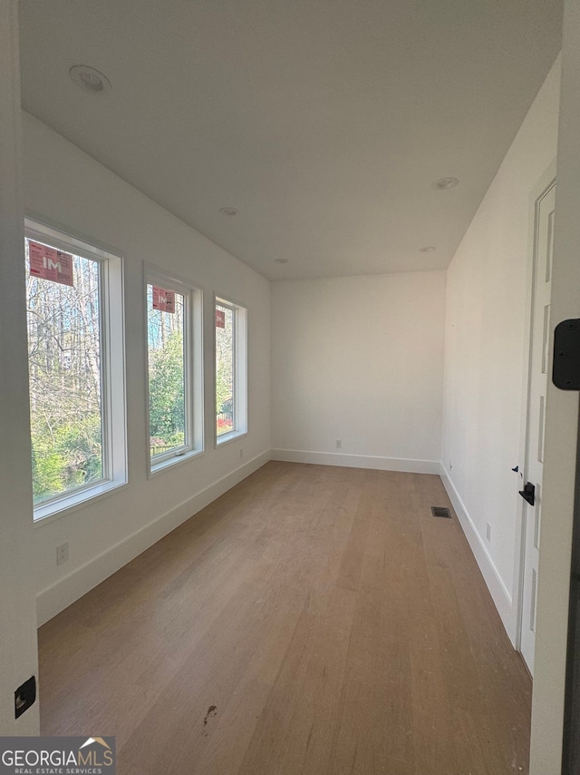 spare room with light wood-style flooring, baseboards, and visible vents