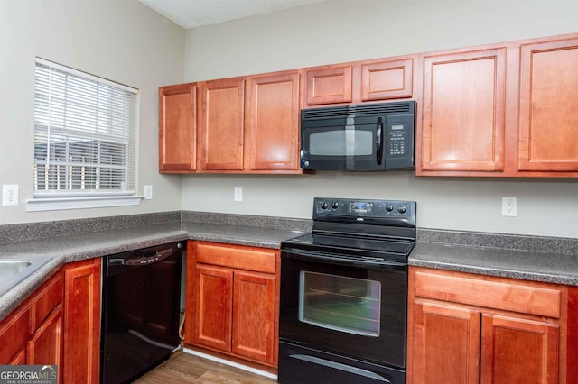 kitchen featuring dark hardwood / wood-style floors and black appliances