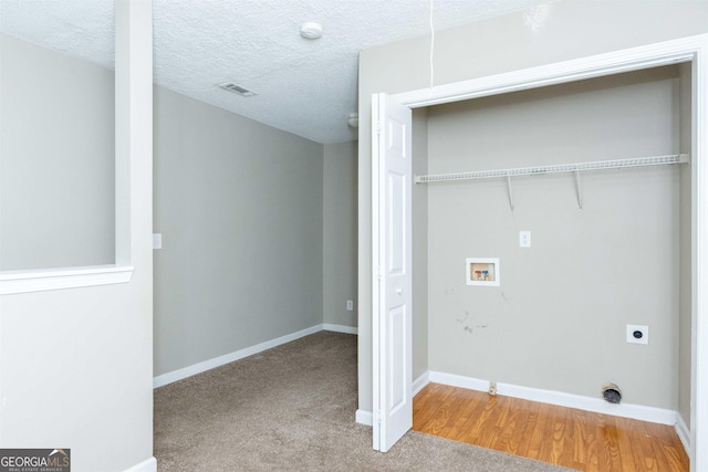 laundry room featuring electric dryer hookup, carpet flooring, washer hookup, and a textured ceiling