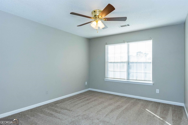 empty room with carpet, a textured ceiling, and ceiling fan