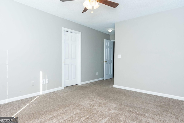 empty room with ceiling fan, carpet, and a textured ceiling