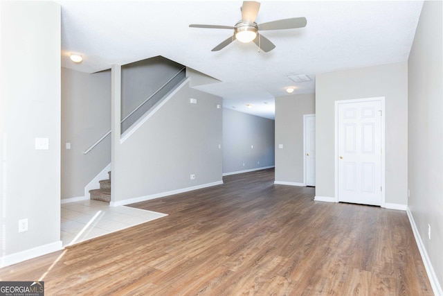 unfurnished living room featuring ceiling fan and wood-type flooring