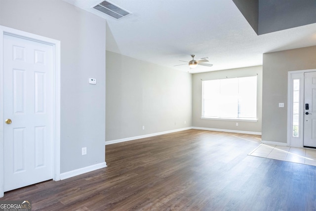 interior space featuring a textured ceiling, ceiling fan, and dark wood-type flooring