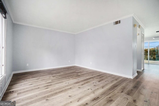 empty room featuring light hardwood / wood-style floors and ornamental molding