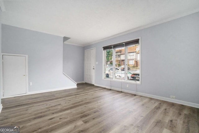 unfurnished room featuring wood-type flooring and crown molding