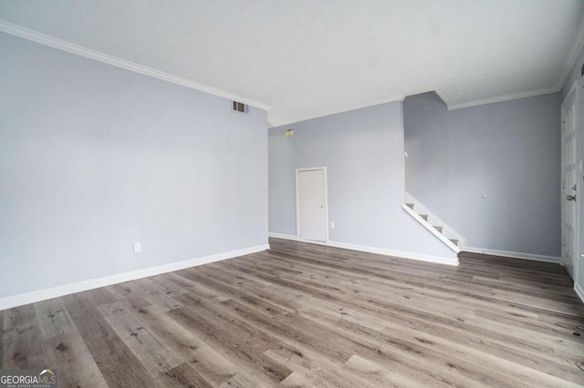 unfurnished room with light hardwood / wood-style floors and crown molding