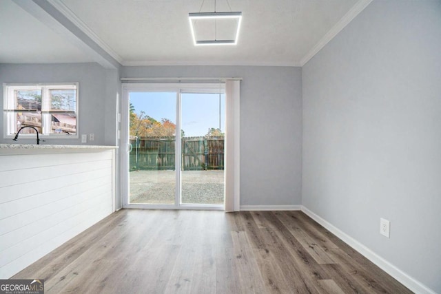 spare room featuring sink, wood-type flooring, and ornamental molding