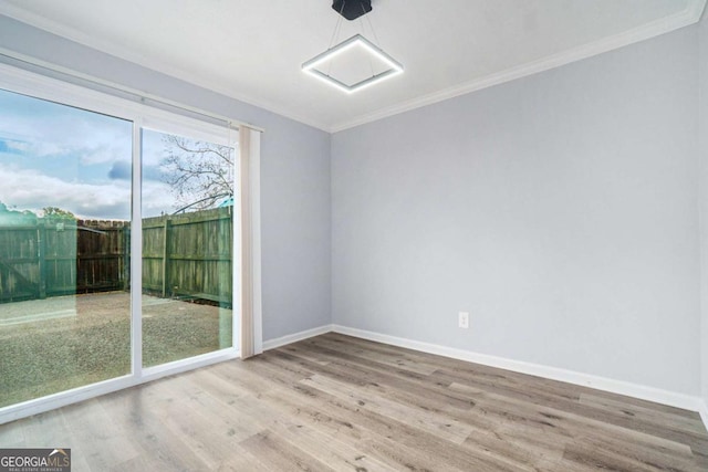 spare room with hardwood / wood-style floors and crown molding