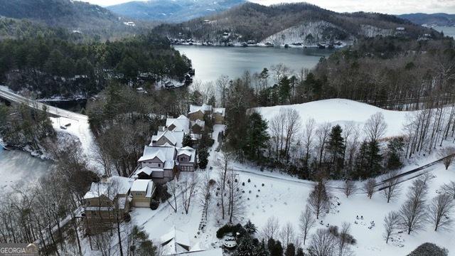 snowy aerial view with a water and mountain view