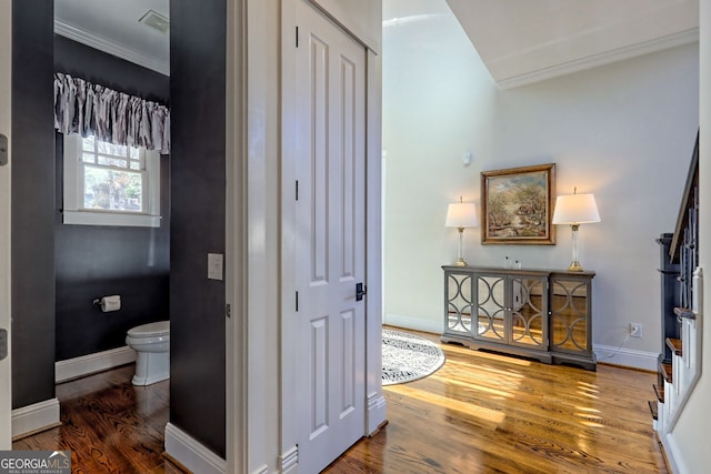 hallway featuring ornamental molding and wood-type flooring