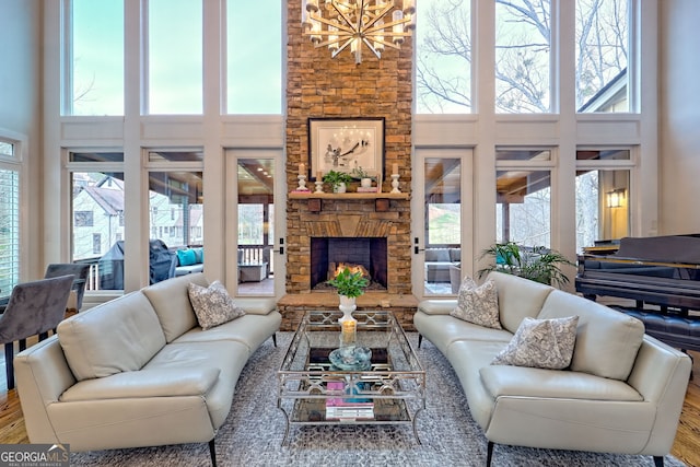 living room featuring a towering ceiling, a fireplace, and wood-type flooring