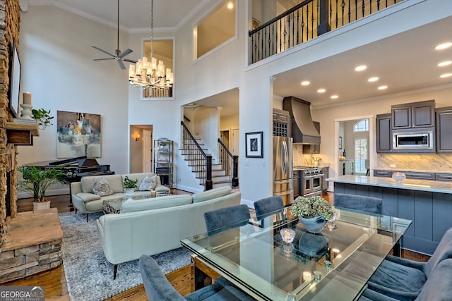 dining space with a towering ceiling, wood-type flooring, and ornamental molding