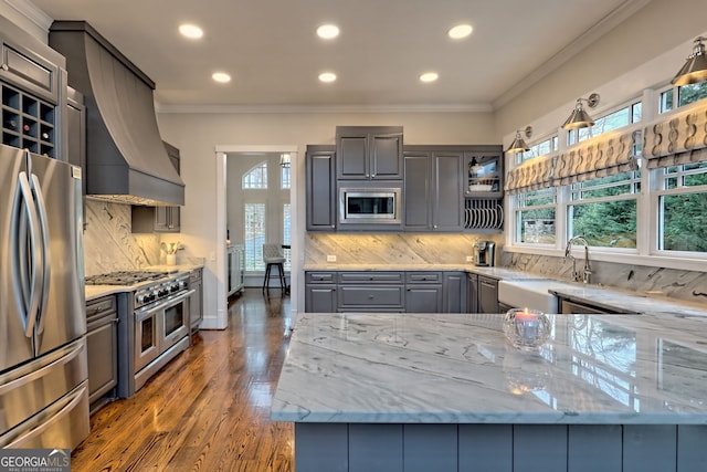 kitchen featuring gray cabinets, stainless steel appliances, light stone countertops, ornamental molding, and decorative backsplash