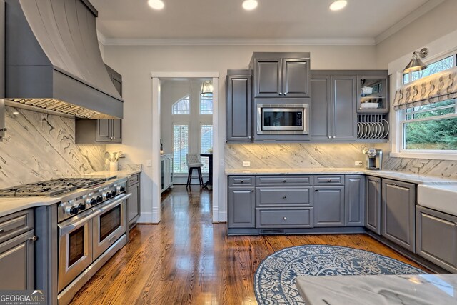 kitchen featuring stainless steel appliances, custom exhaust hood, backsplash, and gray cabinetry