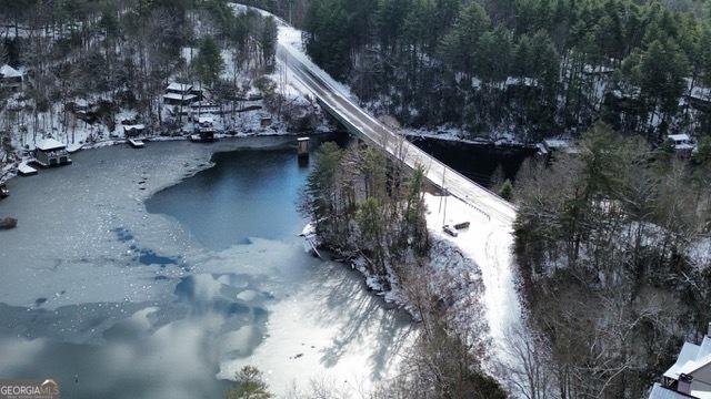 snowy aerial view featuring a water view