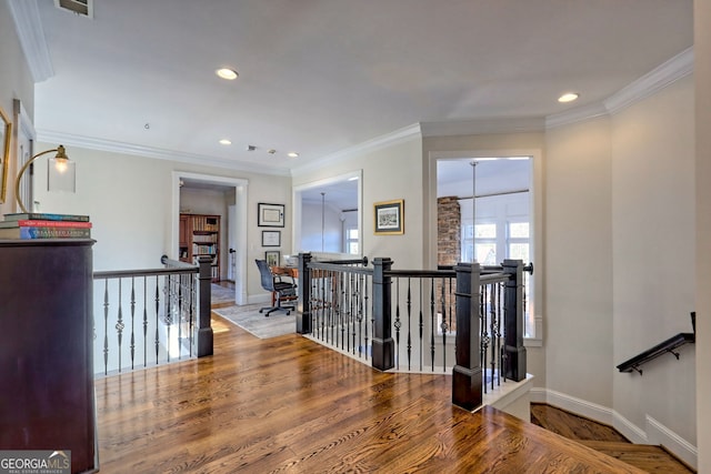 hallway featuring wood-type flooring, an inviting chandelier, and crown molding