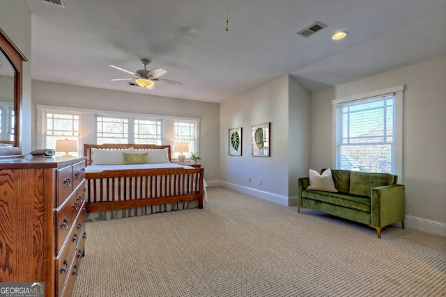 carpeted bedroom with ceiling fan and multiple windows