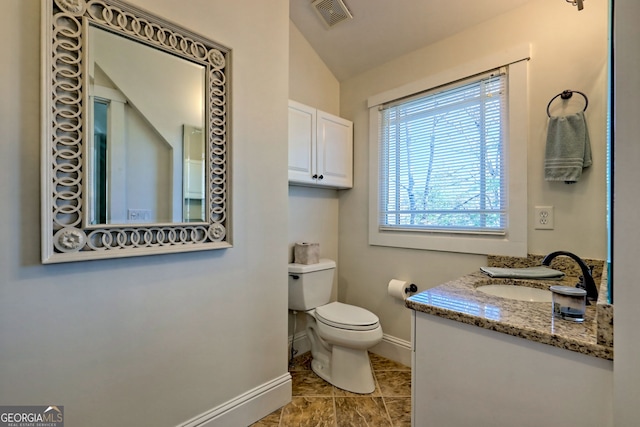 bathroom featuring lofted ceiling, toilet, and vanity