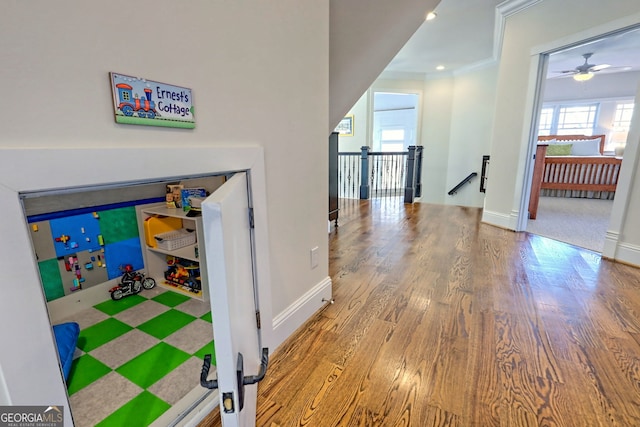 corridor with crown molding and wood-type flooring