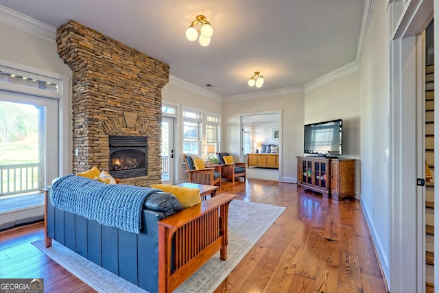 living room with a healthy amount of sunlight, crown molding, and hardwood / wood-style flooring