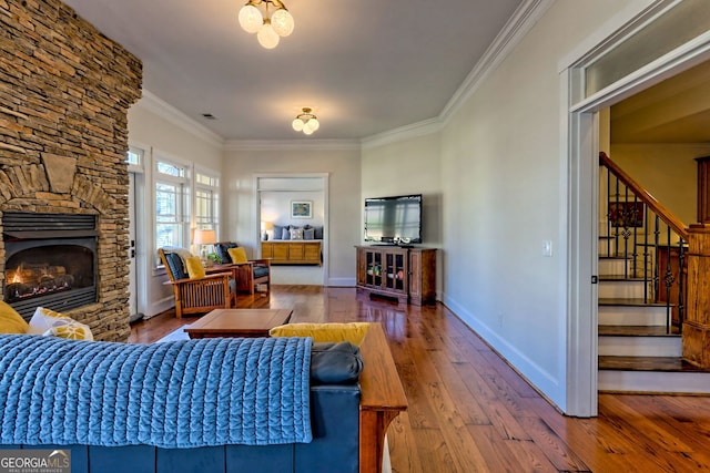 living room with a fireplace, ornamental molding, and hardwood / wood-style flooring