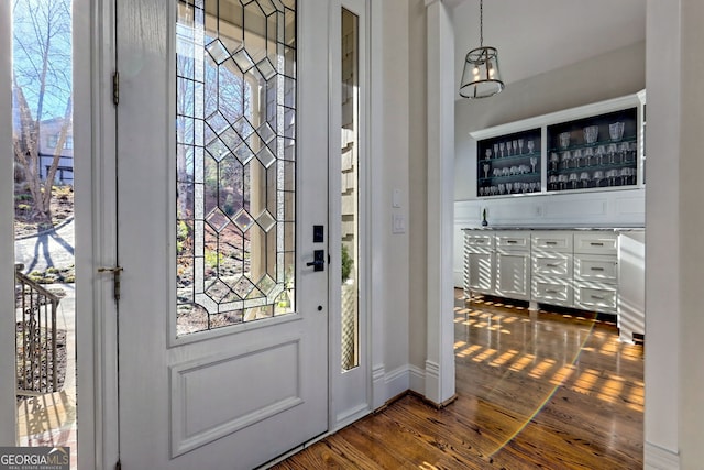 doorway to outside featuring dark hardwood / wood-style flooring and bar area