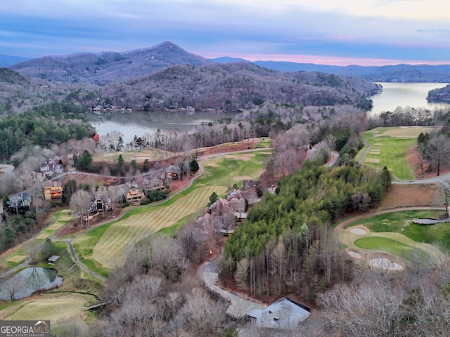 aerial view at dusk featuring a water and mountain view