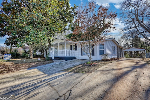 view of front of home with a detached carport, covered porch, and driveway