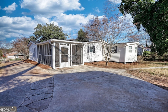 view of front of house featuring a sunroom and concrete driveway