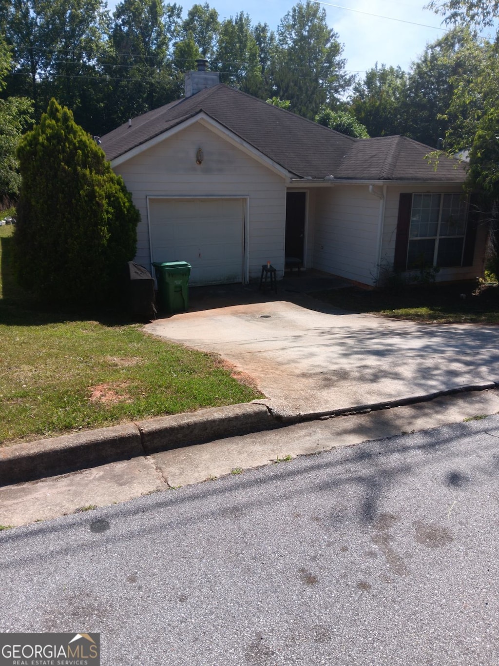 ranch-style home with a front yard and a garage