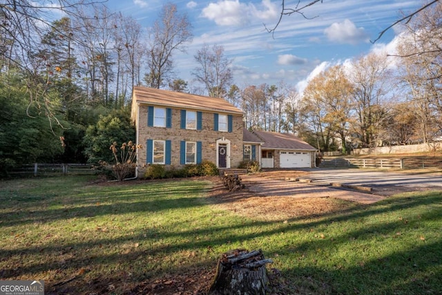 colonial-style house featuring a front yard and a garage