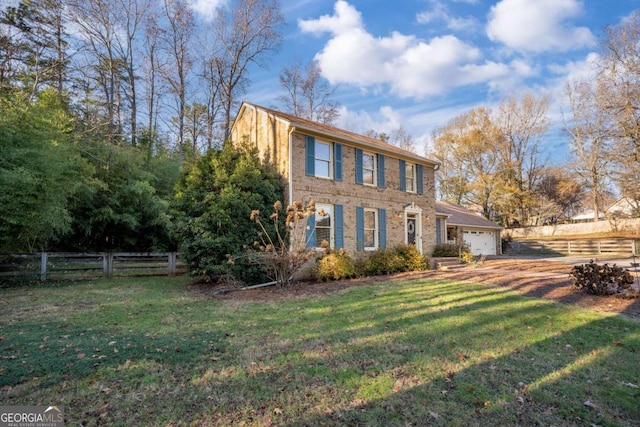 colonial home with a front yard and a garage