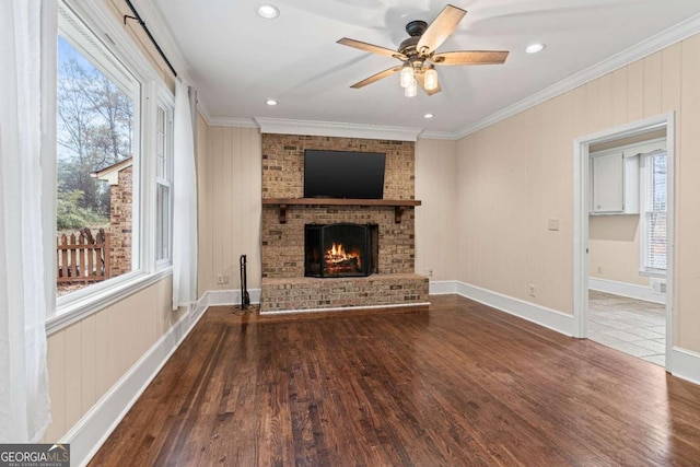 unfurnished living room featuring a fireplace, hardwood / wood-style flooring, crown molding, and ceiling fan