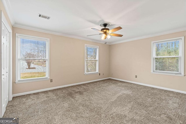 spare room featuring ornamental molding, carpet flooring, and ceiling fan