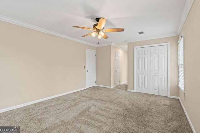 unfurnished bedroom featuring a closet, ceiling fan, carpet flooring, and ornamental molding