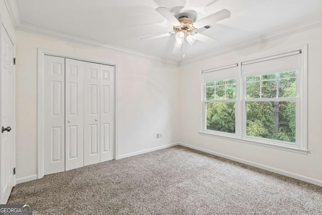 unfurnished bedroom featuring a closet, ceiling fan, carpet floors, and ornamental molding