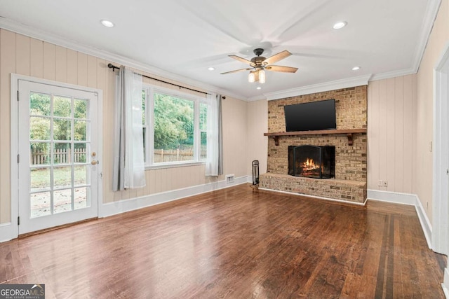 unfurnished living room featuring a fireplace, hardwood / wood-style floors, crown molding, and ceiling fan