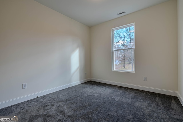 spare room with dark colored carpet