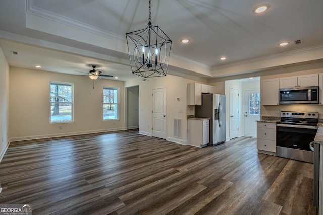 kitchen featuring dark wood-type flooring, white cabinets, ceiling fan with notable chandelier, ornamental molding, and appliances with stainless steel finishes