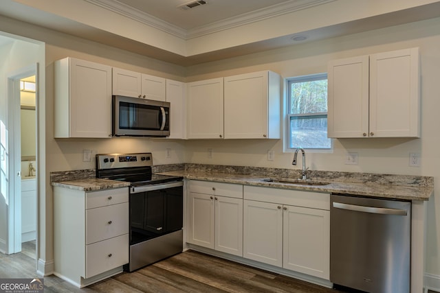 kitchen with stainless steel appliances, dark wood-type flooring, crown molding, sink, and white cabinetry