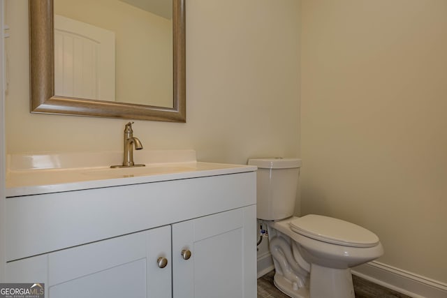 bathroom featuring hardwood / wood-style floors, vanity, and toilet