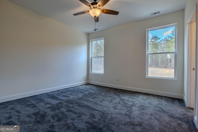 carpeted empty room featuring a wealth of natural light and ceiling fan