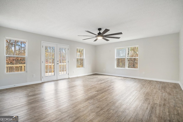 unfurnished room featuring hardwood / wood-style flooring, ceiling fan, a textured ceiling, and a wealth of natural light