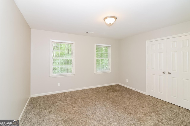 unfurnished bedroom with carpet and a closet