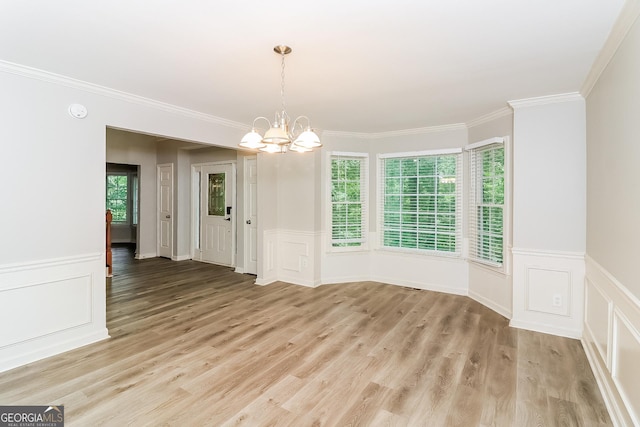 unfurnished dining area featuring crown molding, a notable chandelier, and light wood-type flooring