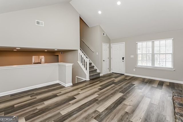 entrance foyer with dark hardwood / wood-style floors and high vaulted ceiling