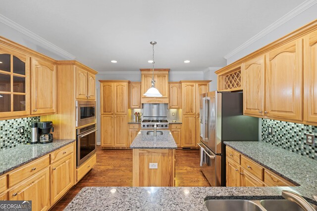 kitchen featuring light stone counters, a kitchen island with sink, stainless steel appliances, a sink, and glass insert cabinets