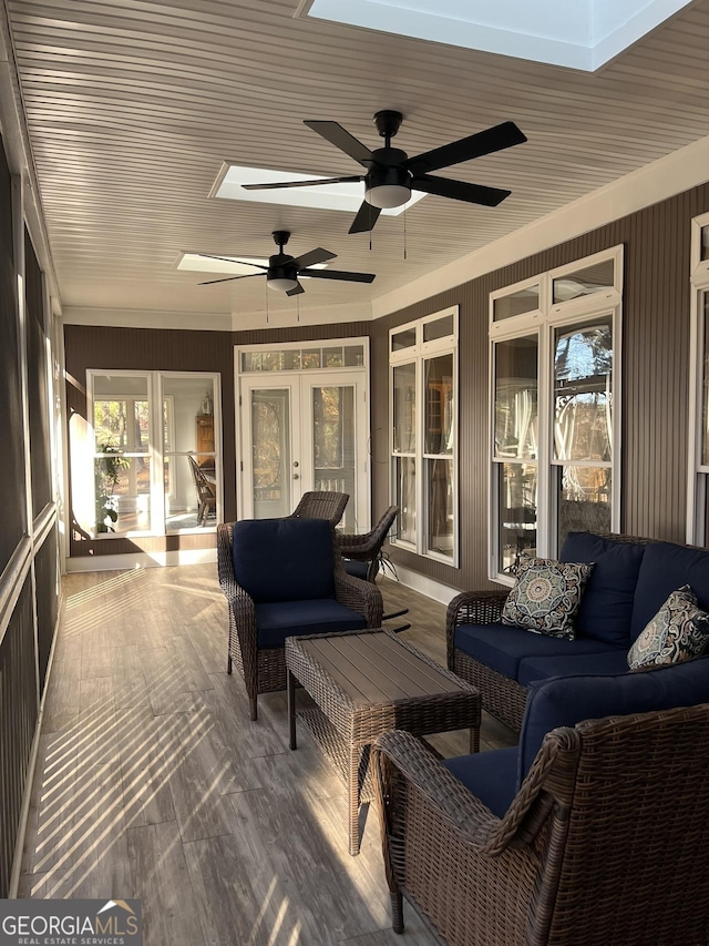 sunroom / solarium featuring french doors, ceiling fan, a skylight, and wooden ceiling